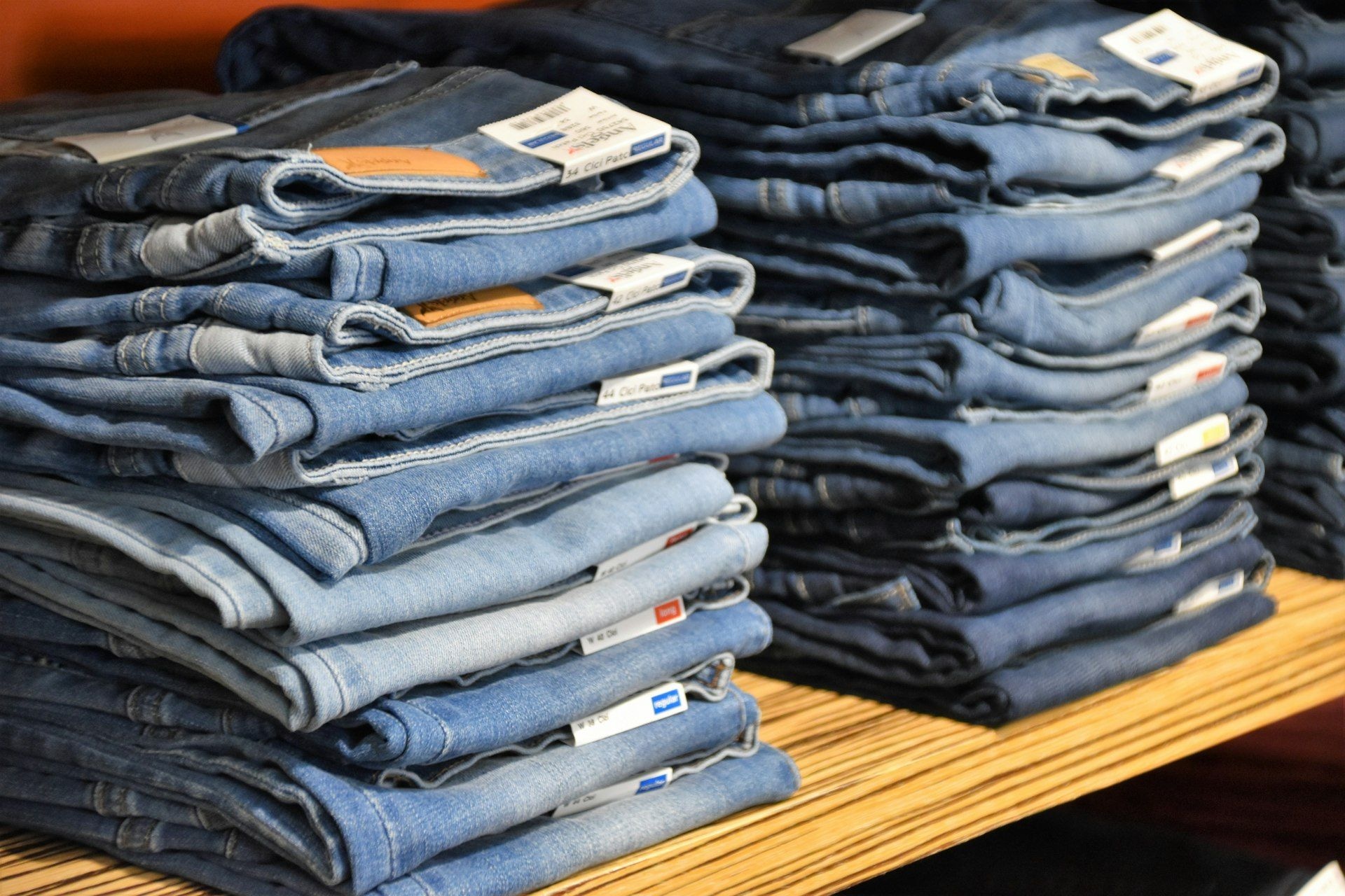 Folded denim stacked by wash on a display table