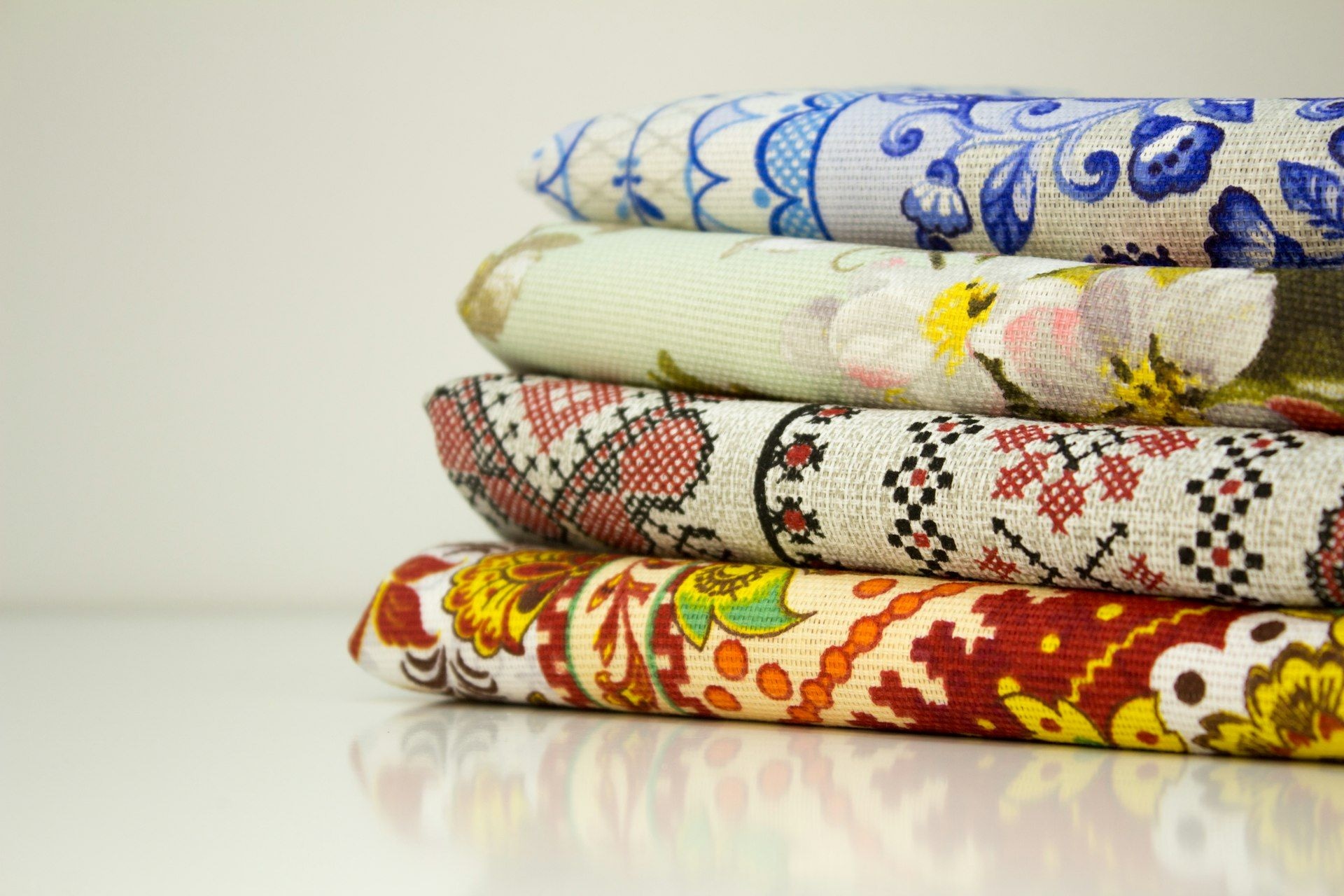 Folded fabrics stacked by pattern on a shop table