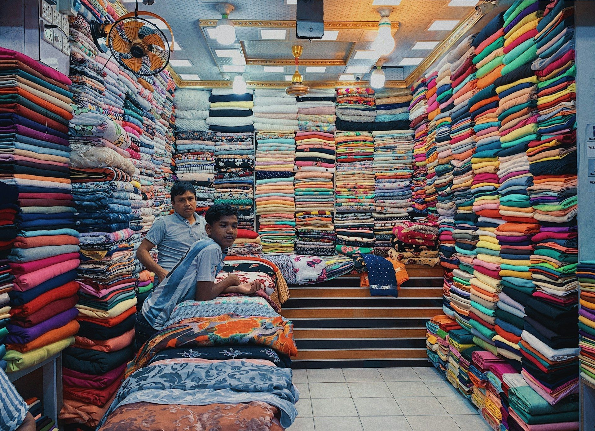 Merchants working amid stacked bolts of cloth