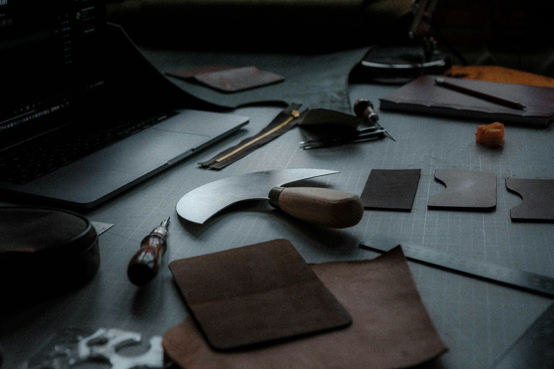 Leather pieces and hand tools laid out on a workbench
