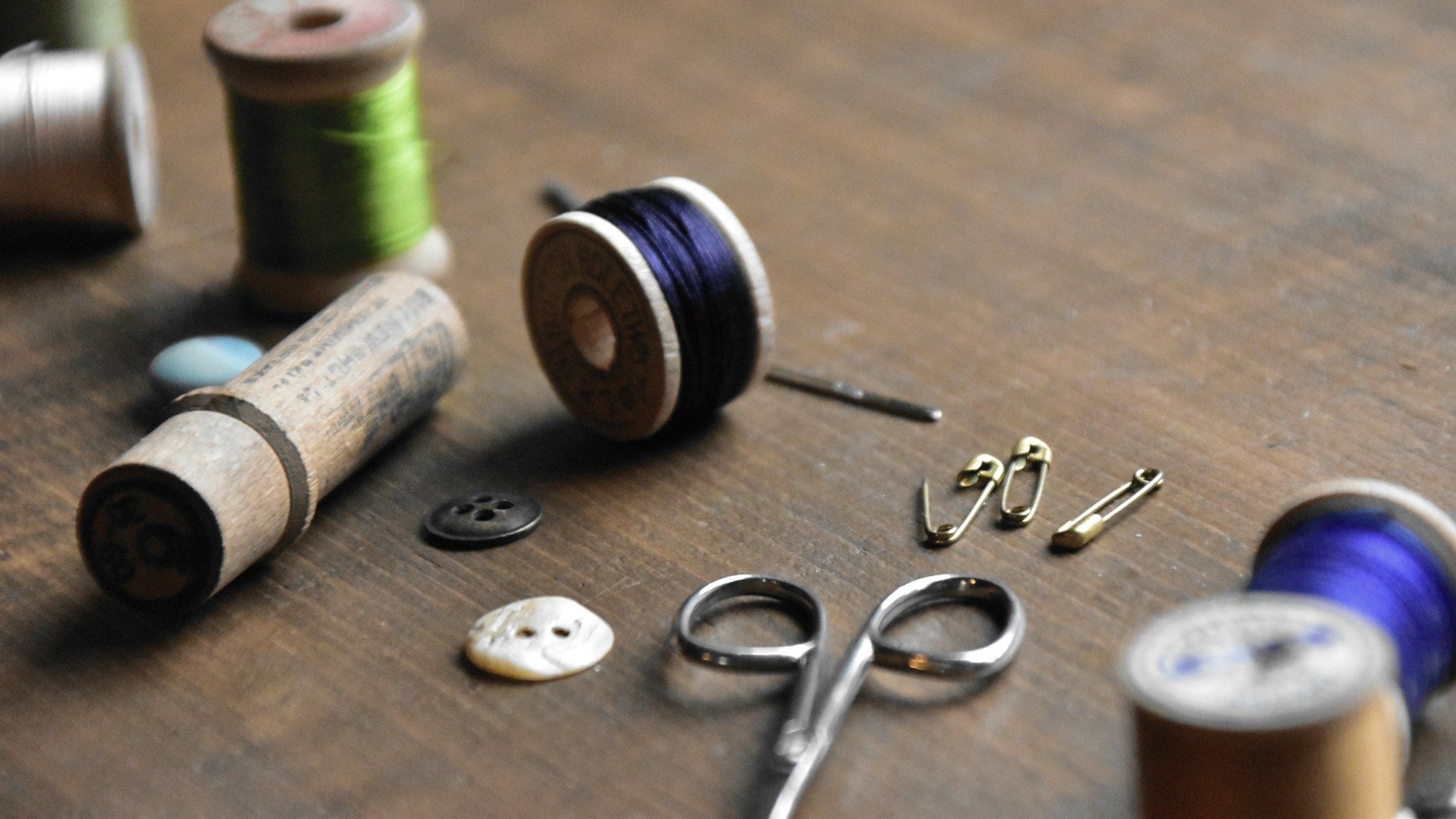 Buttons, thread and haberdashery tools laid out on a bench
