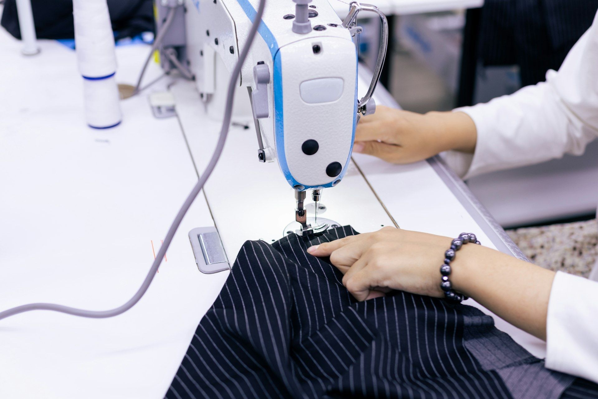 A machinist finishing a garment at an industrial sewing machine