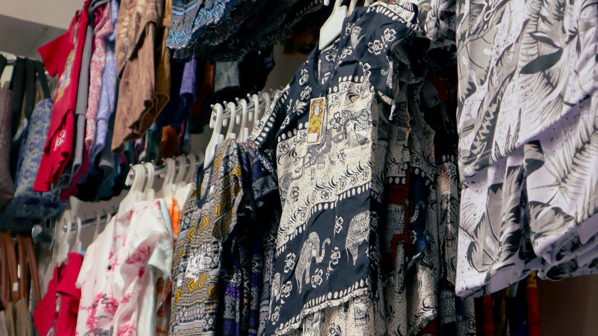 Garments hanging on display racks across a wholesale floor