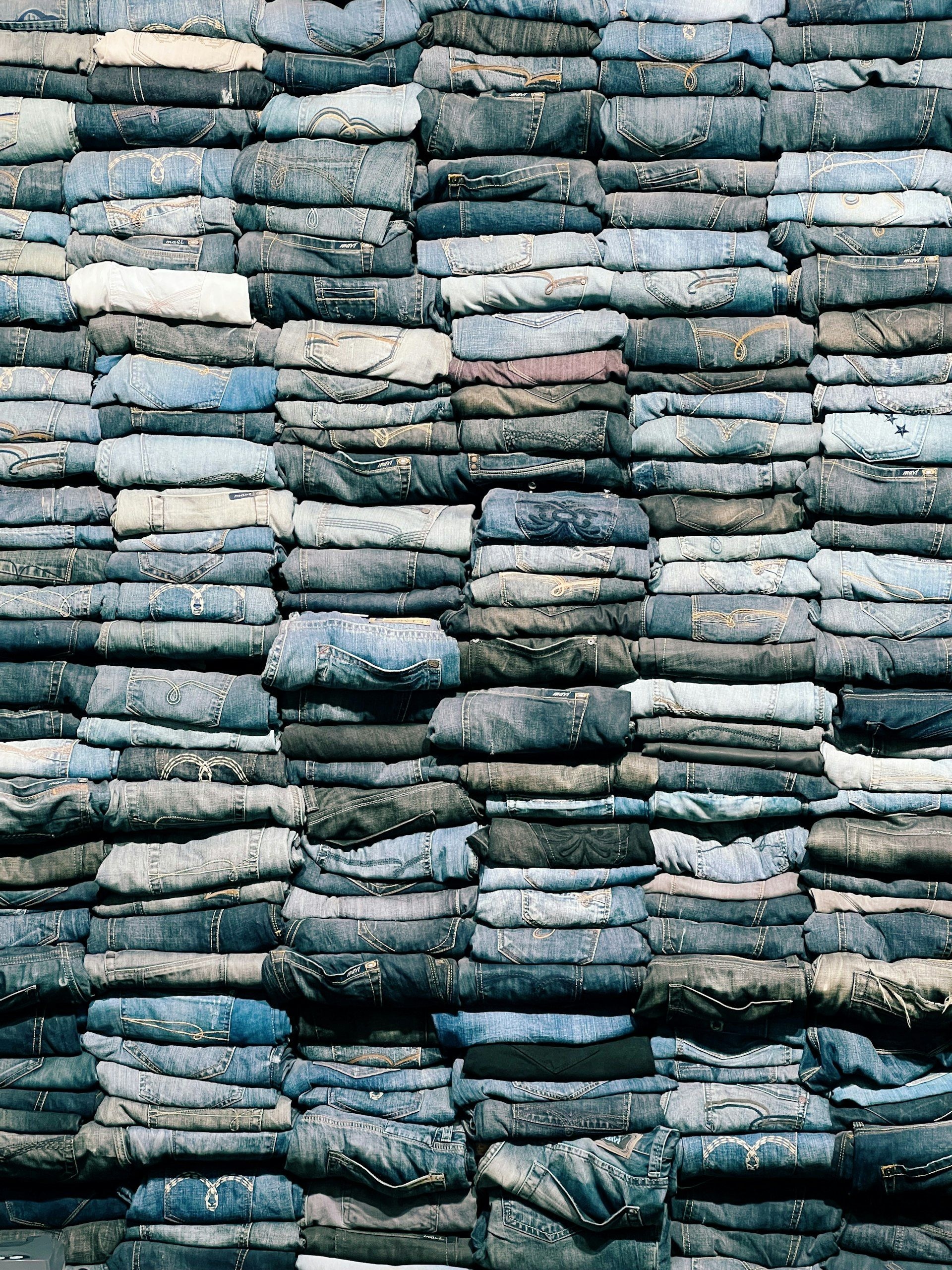 Folded denim sorted by shade on a wholesale shelf