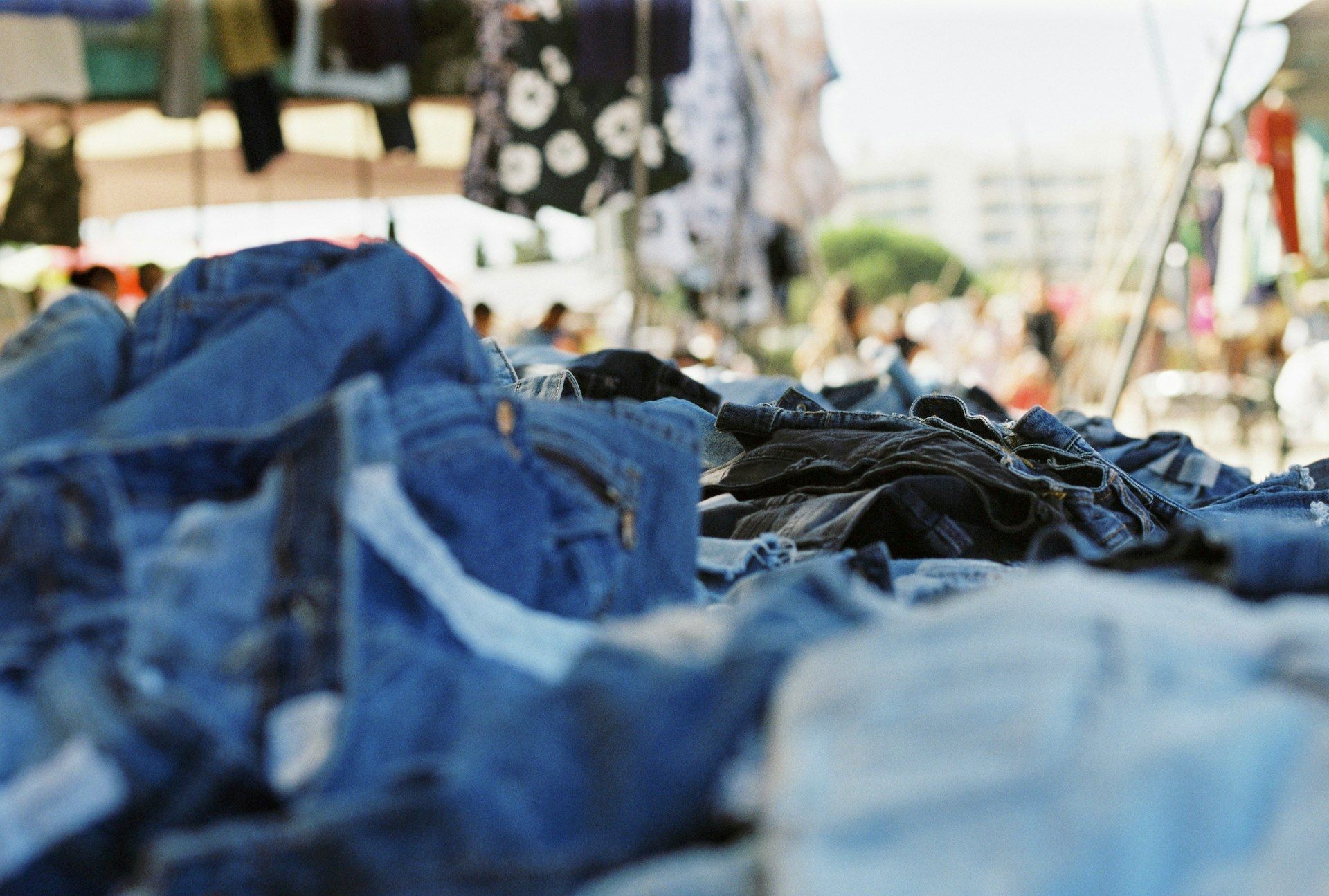 Folded denim jeans stacked on a market stall table