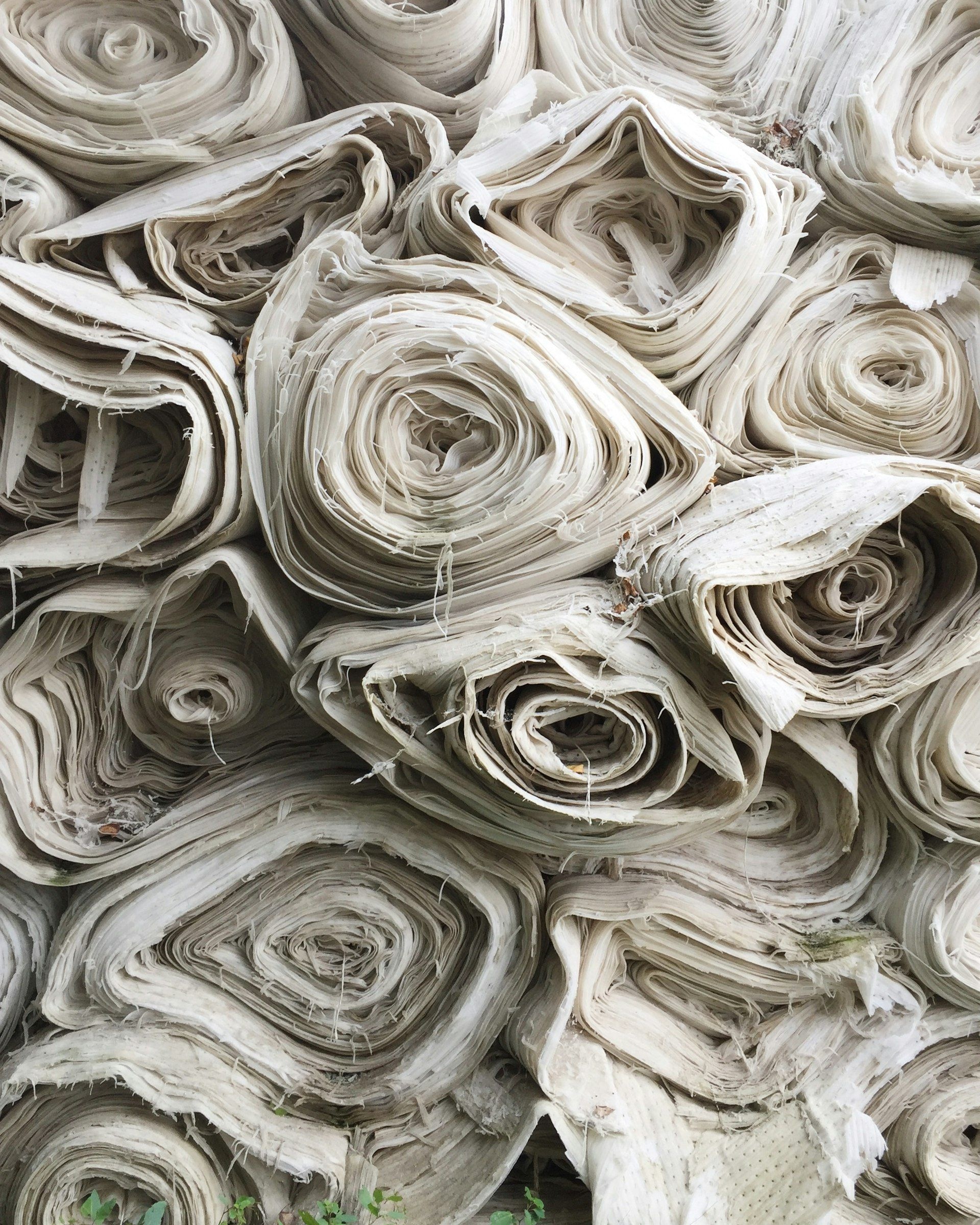 Bolts of cloth stacked in a fabric warehouse