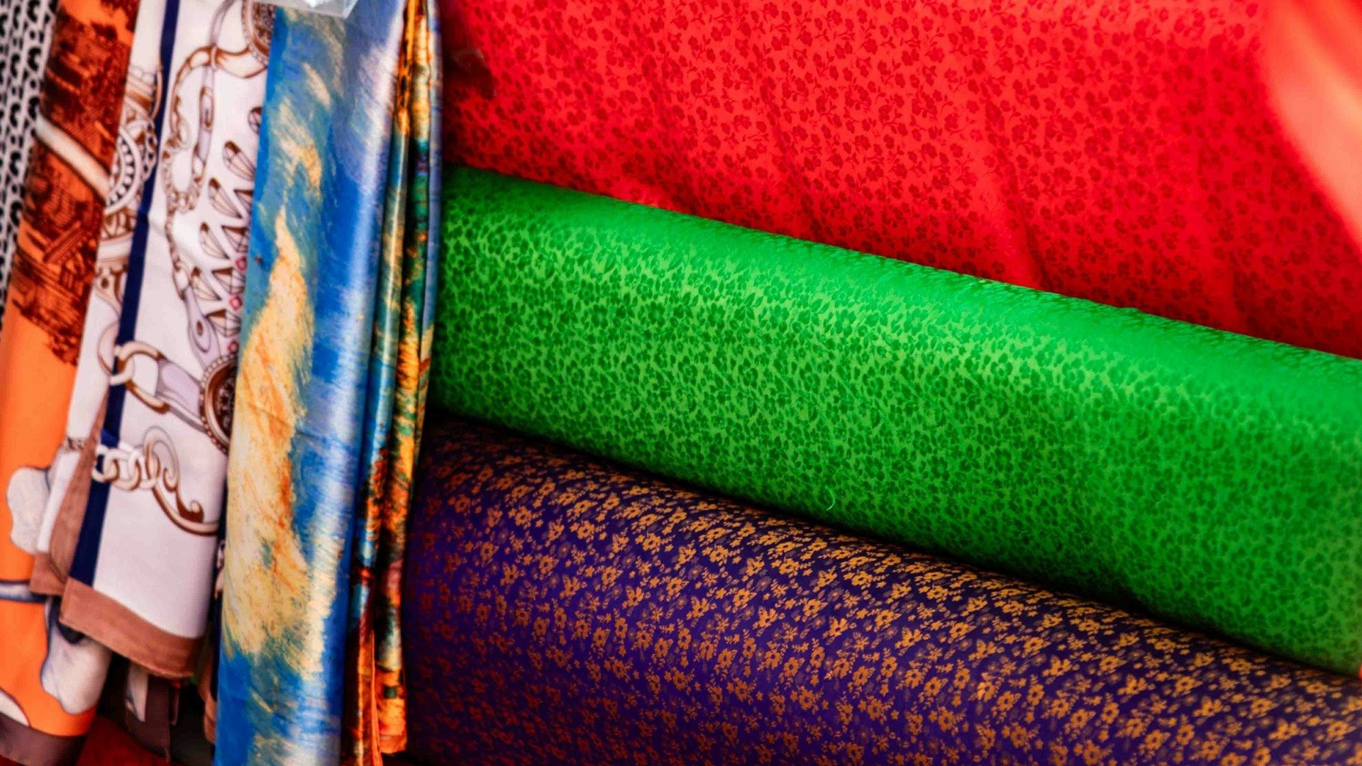 Rolls of patterned fabric on a wholesale market stand