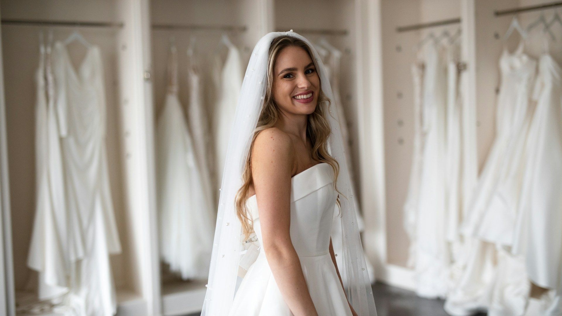 A buyer reviewing bridal gowns in a showroom