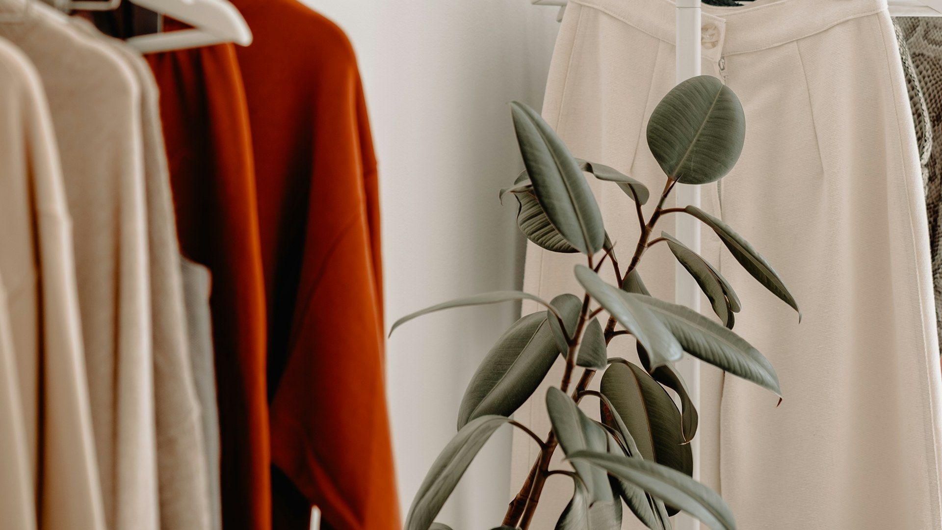 Clothing rails of neutral-toned garments in a wholesale showroom